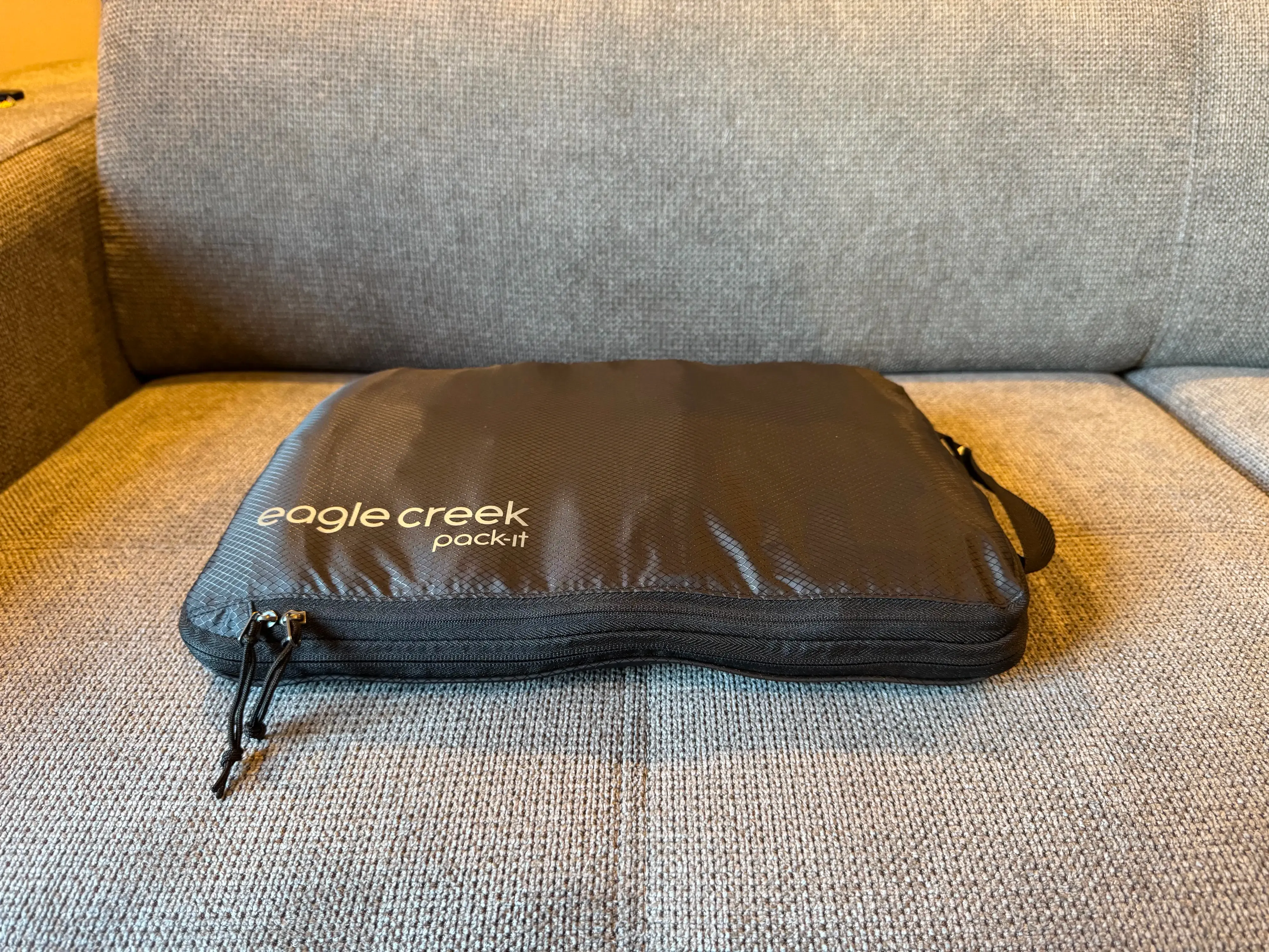 A photo of a compression cube flattened with all zippers closed. It looks half as thick as on the previous photo.