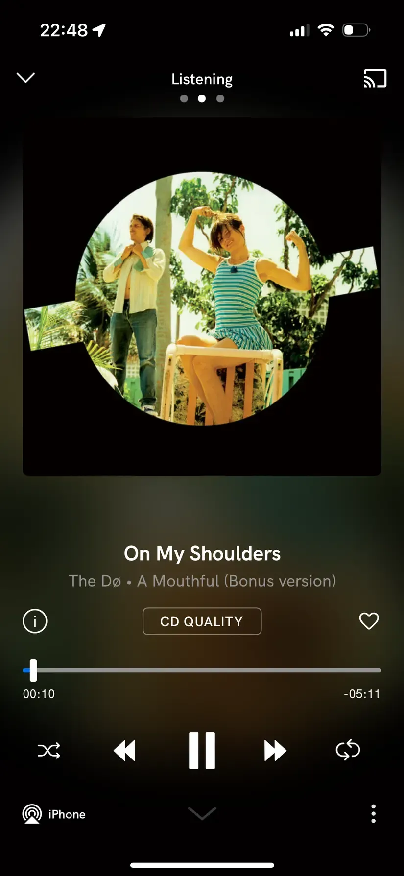 A screenshot of the iOS app Qobus. The main area on top displays the album cover, then below it the name of the song, then the name of the artist and the album. At the bottom there is a media player with the usual controls.